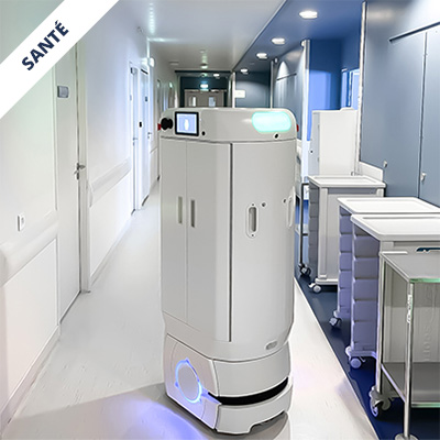 Autonomous white hospital service robot with a touchscreen, moving down a clean clinical corridor with carts nearby.