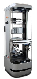 Enclosed industrial 3D printer with a vertical build chamber and the door open, showing the build platform inside.