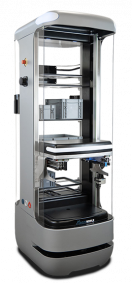 Enclosed industrial 3D printer with a vertical build chamber and the door open, showing the build platform inside.